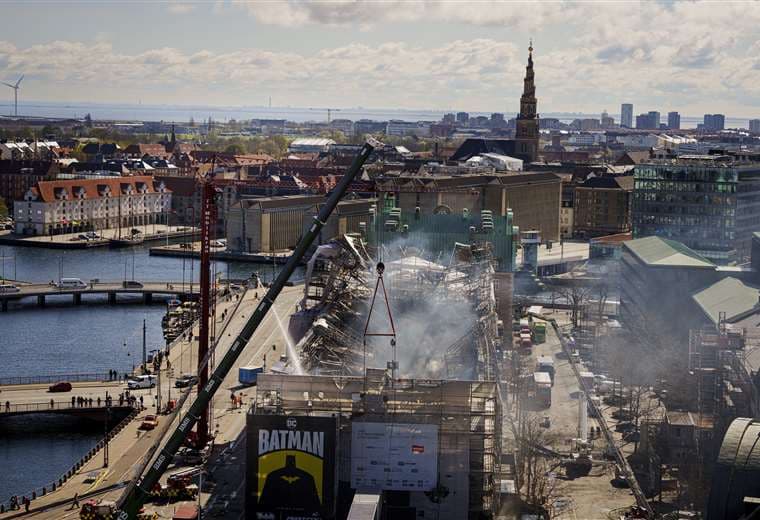  Bomberos rocían agua sobre los escombros del edificio de la Bolsa de Copenhague / AFP