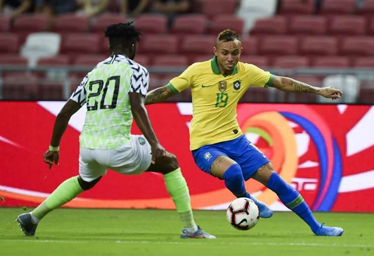 El brasileño Everton (19) intenta superar al nigeriano Chidozie (20) en el amistoso en Singapur. Foto. AFP 