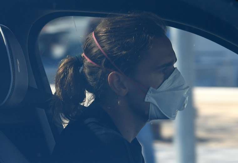El delantero francés Antoine Griezmann llegó en su vehículo y con la mascarilla puesta. Foto (AFP)