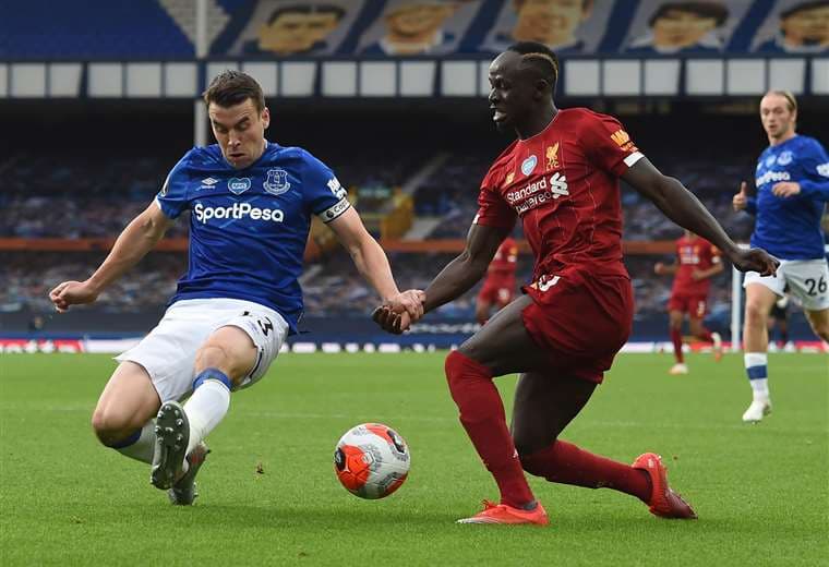 Una de las figuras del Liverpool, Sadio Mane (dcha.), intenta eludir la marca del defensor del Everton Seamus Coleman. Foto: AFP