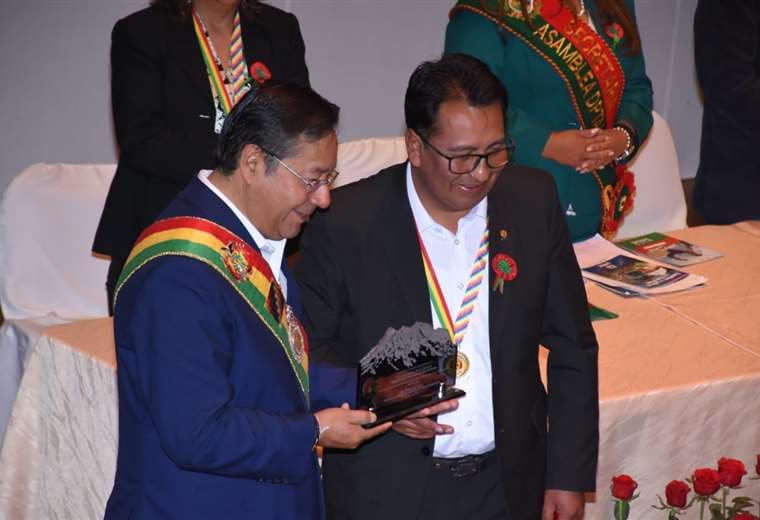 El presidente Luis Arce sostiene una estatuilla de reconocimiento entregado por el MAS