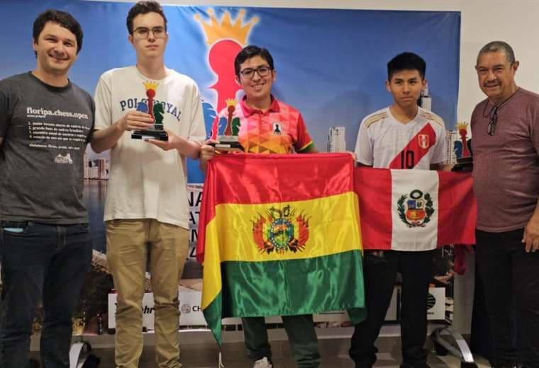 Mauricio Tapia (c.) con su trofeo de campeón y con la bandera boliviana. Foto: FBA