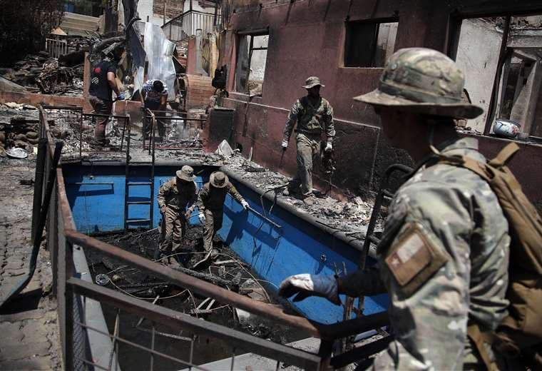 Militares chilenos ayudan en la limpieza de casas quemadas en Villa Independencia / AFP