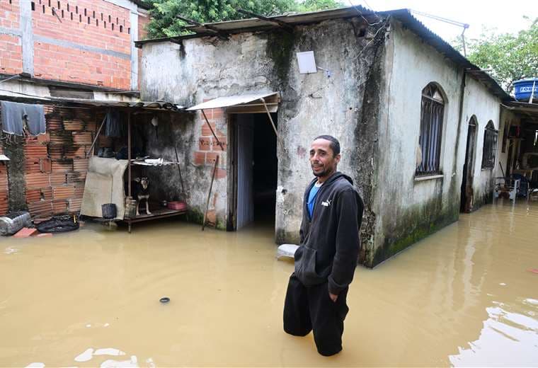 Un hombre en una calle inundada en un barrio en las afueras de Río de Janeiro / AFP