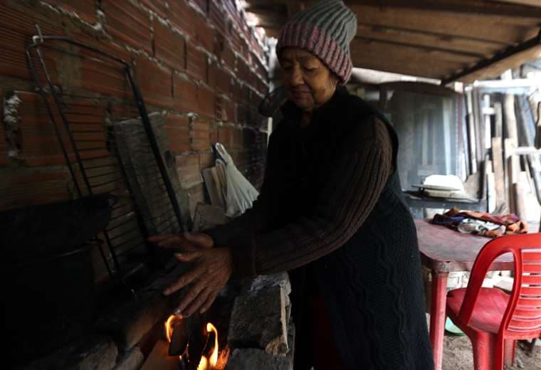 María Santos cocina a leña y aprovecha de calentarse en el fuego. Foto: Fuad Landívar 