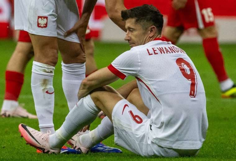 Lewandowski en el piso tras sentir molestias en su rodilla. Foto: AFP