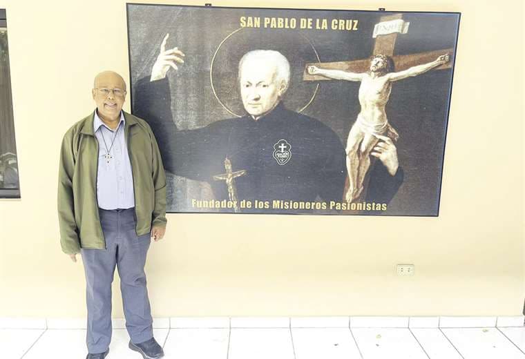 El padre Joachim posa junto al cuadro de San Pablo de la Cruz, fundador de los pasionista