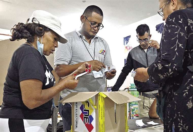 Venezolanos vigilan las boletas de votación. Foto AFP