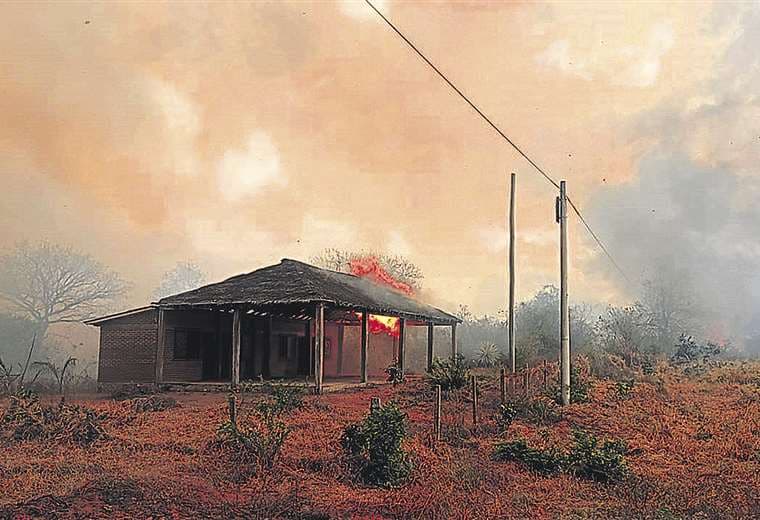 Las llamas consumen una cabaña. Los bomberos trabajan arduamente para contener el fuego