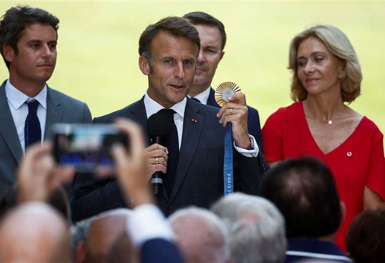  El presidente de Francia, Emmanuel Macron, sostiene una medalla de oro olímpica / AFP