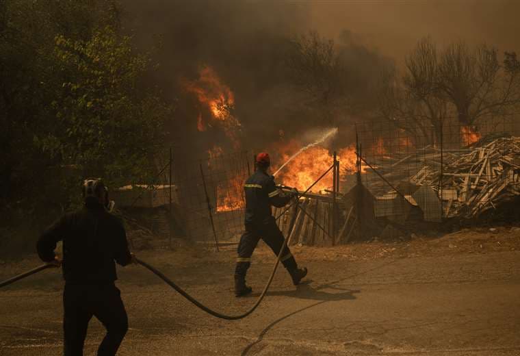 Efectivos combaten el fuego que avanza por los suburbios de Atenas / AFP