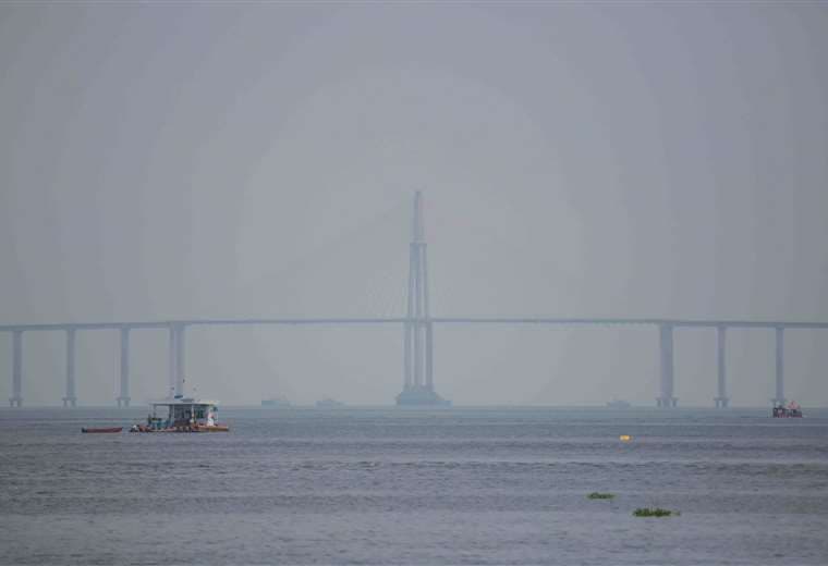 Vista del puente Jornalista Phelippe Daou sobre el río Negro cubierto por el humo/AFP