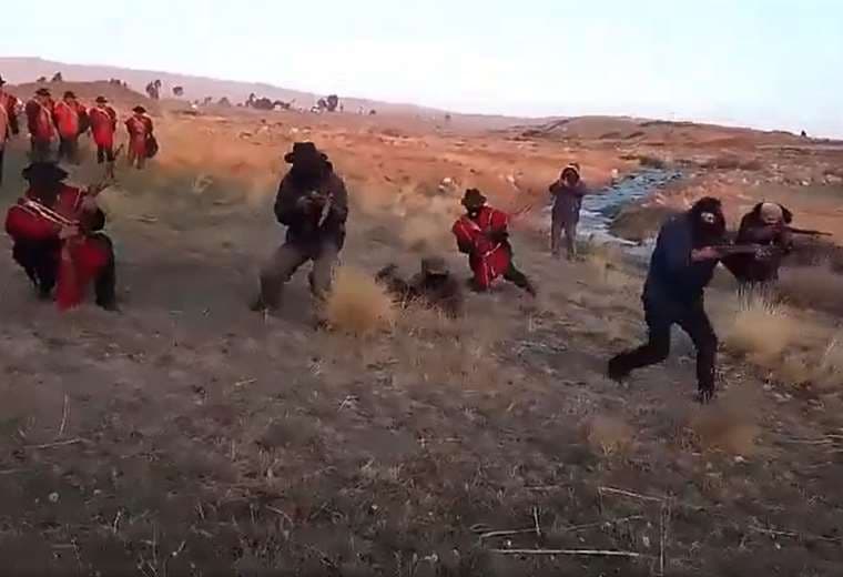 Ponchos rojos y encapuchados armdos. Foto: Captura de video