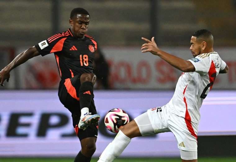 El colombiano Sinisterra y el peruano Callens en la disputa del balón. Foto: AFP