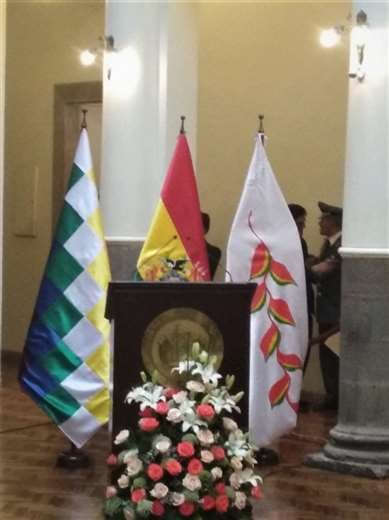 La bandera de la flor del Patujú a la derecha; en medio, la rojo, amarillo y verde; a la izquierda, la wiphala