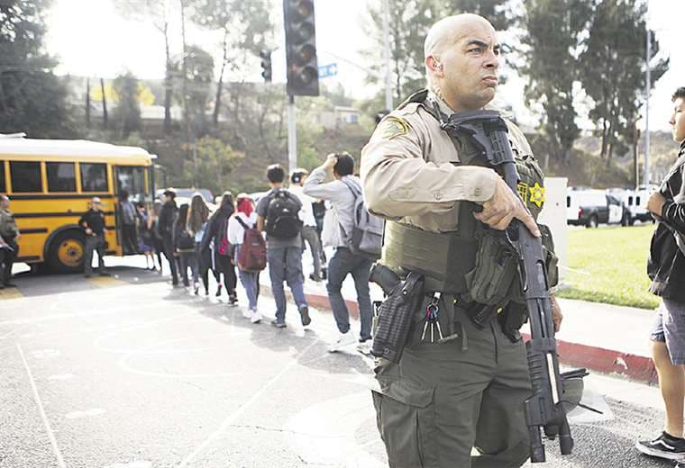 Un oficial de la Policía controla la salida de los estudiantes del liceo. Foto: AFP