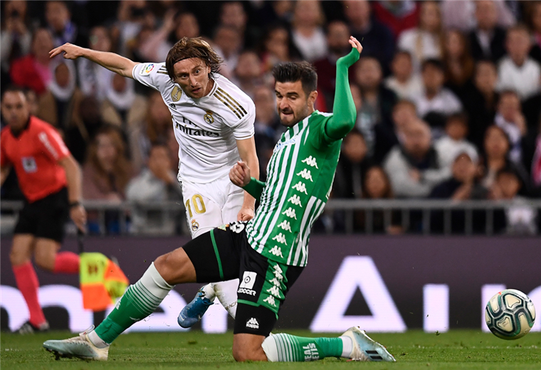 Luka Modric saca el remate ante la marca de Barragán. Foto: AFP
