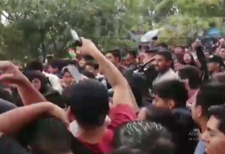 Un hombre alza el arma en medio de la multitud