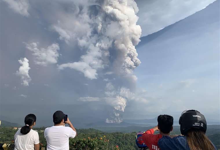 Turistas fotografían la enorme columna de humo del volcán Taal, cerca de Manila, capital de Filipinas. Foto: AFP