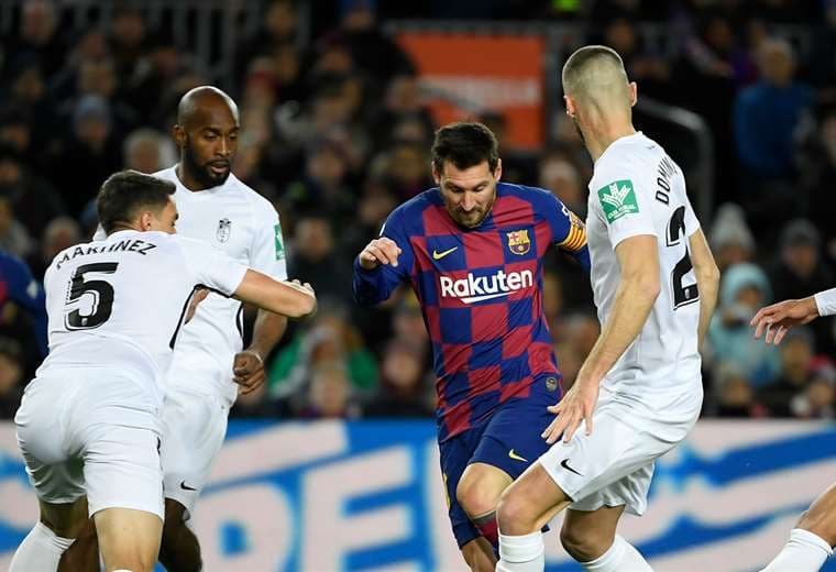 Messi domina el balón rodeado de rivales en el partido ante Granada. Foto. AFP 