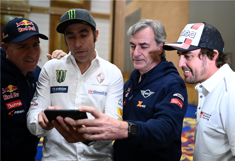 Stephane Peterhansel mira el video de Nani Roma, junto a los españoles Carlos Sainz y Frenando Alonso. Foto: AFP