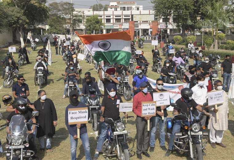 Motociclistas en campaña para el uso de mascarillas en India. Foto AFP