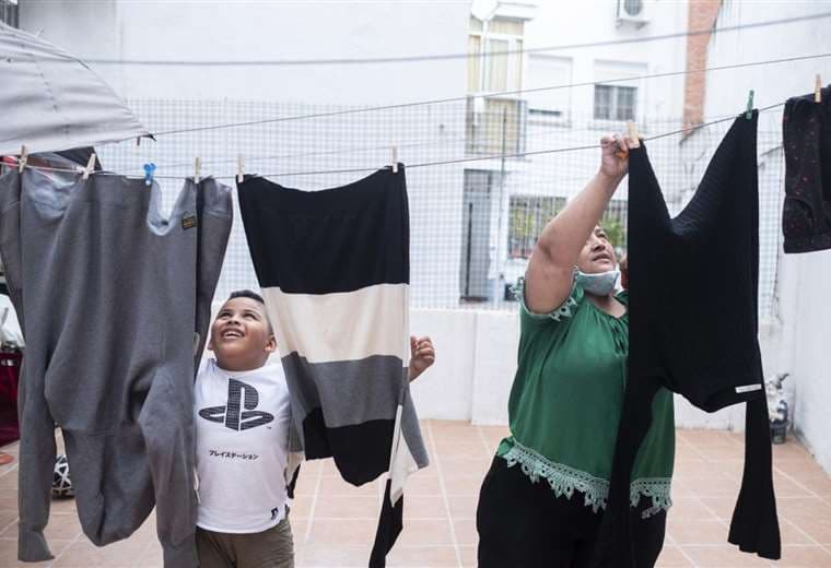 Andrei y Karen tendiendo la ropa en el patio interior de su casa. Foto El País
