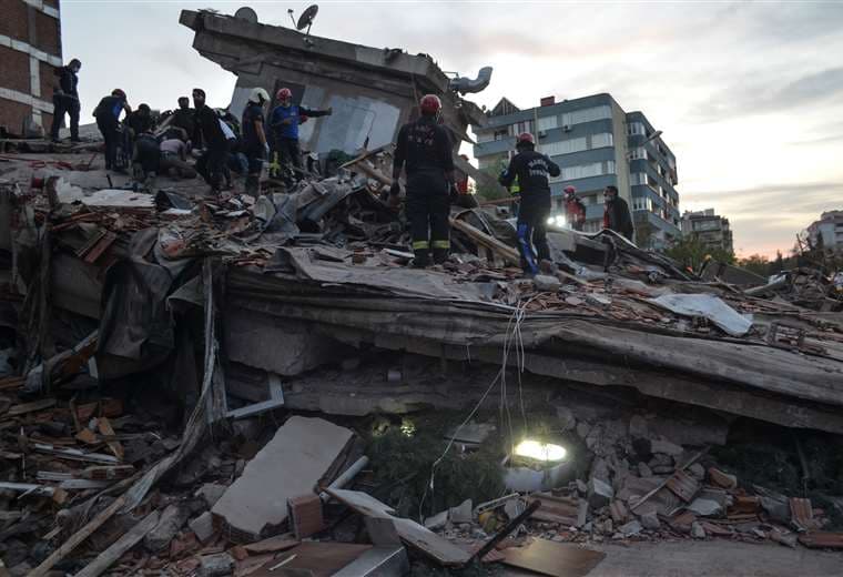 Rescatistas buscan sobrevivientes entre los restos de un edificio. Foto AFP
