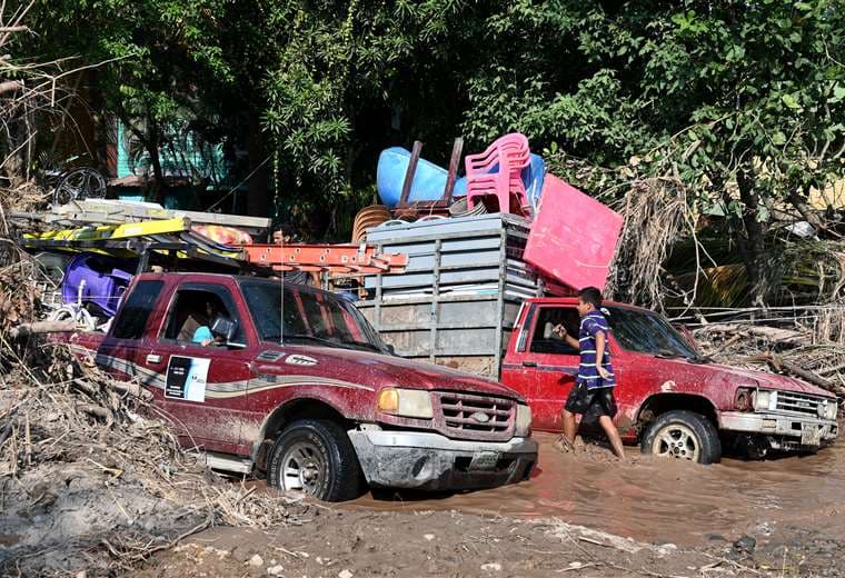 La gente busca resguardarse con sus cosas del paso del ciclón. Foto AFP