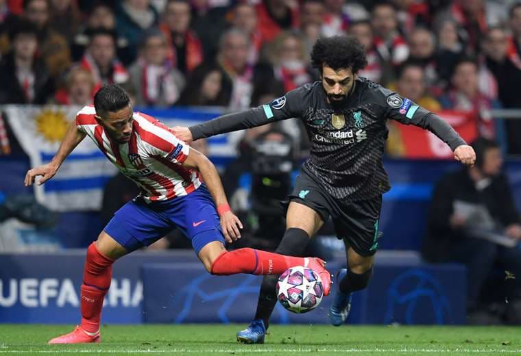 Renan Lodi, del Atlético de Madrid disputa el balón con Salah, de Liverpool. Foto. AFP