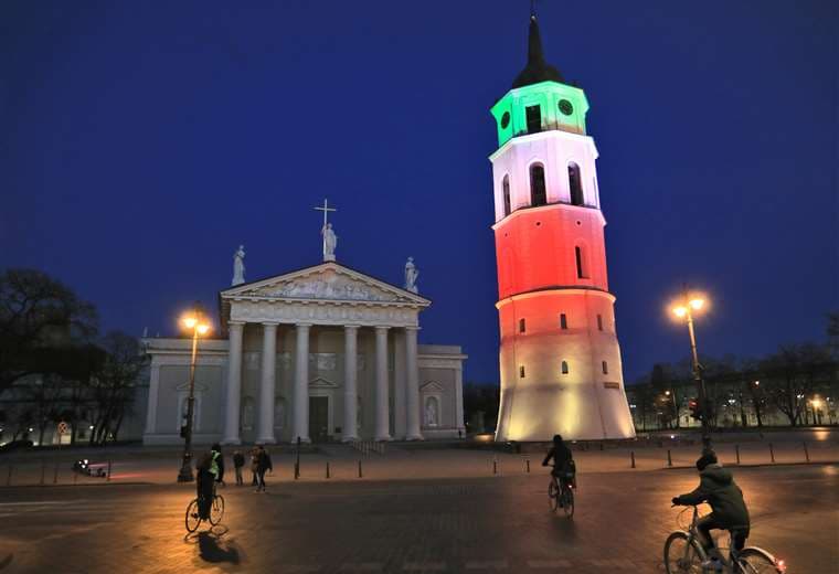 El Campanario de la Plaza de la Catedral de Vilna (Lituania) iluminado con los colores de la bandera de Italia en solidaridad con las víctimas del coronavirus. Foto AFP