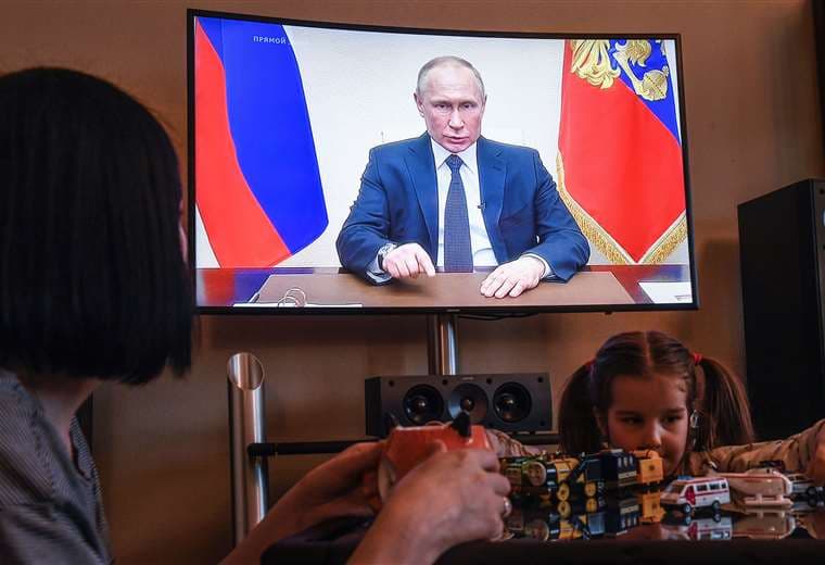 Una mujer moscovita atenta al mensaje del presidente ruso. Foto AFP