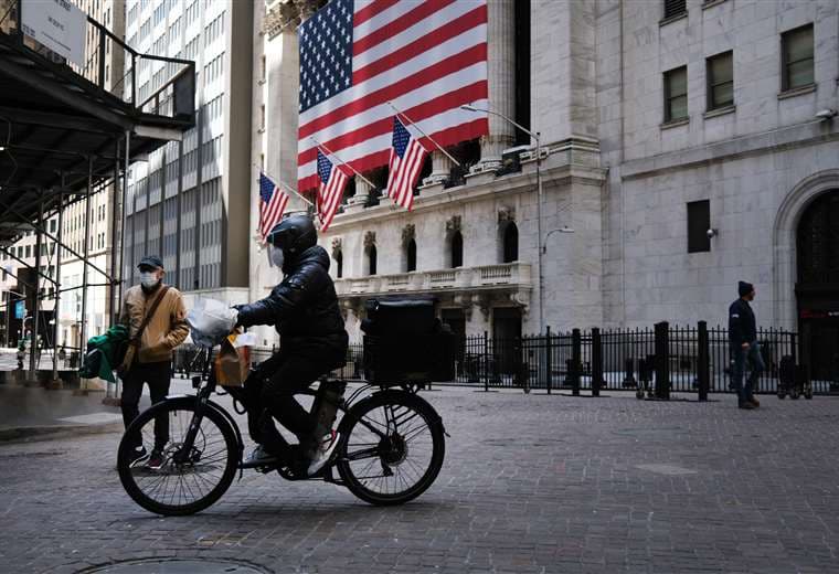 Un ciclista cruza por una calle desierta de Nueva York. Foto AFP
