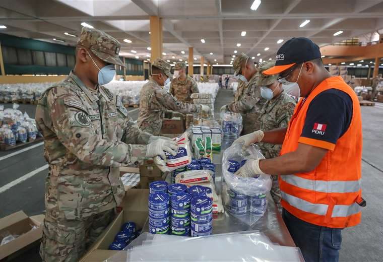 Militares y personal de Defensa Civil seleccionan alimentos para personas carenciadas de Lima. Foto AFP