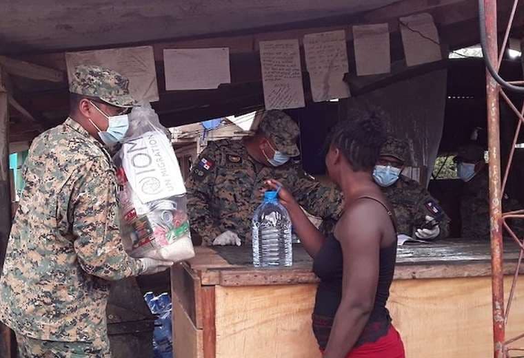 Uno de los alojados recibe una ración de comida de parte de militares. Foto Internet