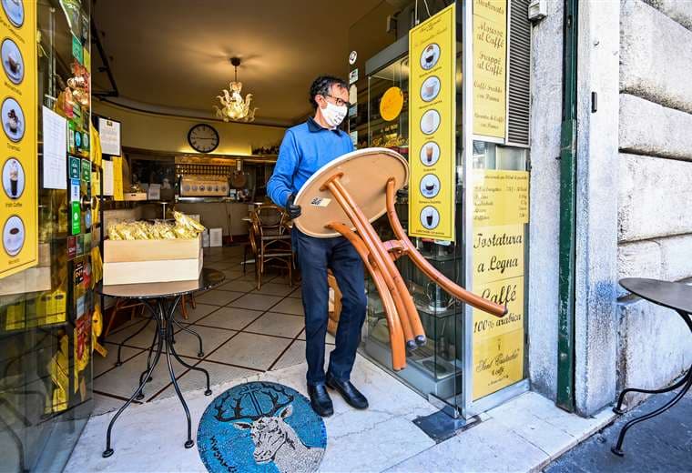 El propietario de un café en Roma alista su local para reanudar la atención. Foto AFP
