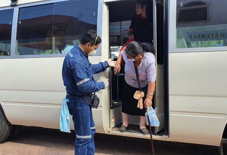 Un colaborador de Fuentes ayuda a una anciana a bajar del microbús. Foto: Fabricio Fuentes