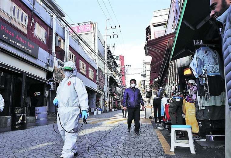 Funcionarios sanitarios desinfectan una calle del distrito Itaewon, en Seúl. Foto Internet