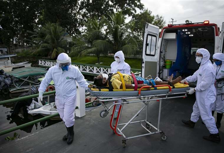 Un enfermo de coronavirus es llevado a un bote ambulancia en la región de Pará, en Brasil. Foto AFP