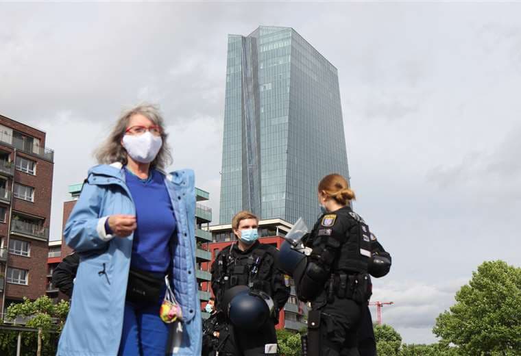 Dos policías vigilan una manifestación contra el confinamiento frente al Banco Central Europeo en Frankfurt. Foto AFP