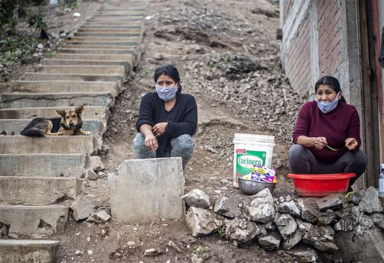 Dos mujeres esperan en un comedor comunitario de la zona de Pamplona Alto, al sur de Lima. Foto AFP