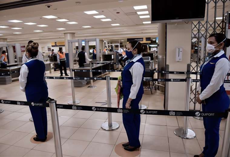 Personal de una aerolínea espera a pasajeros en el aeropuerto de Quito. Foto AFP
