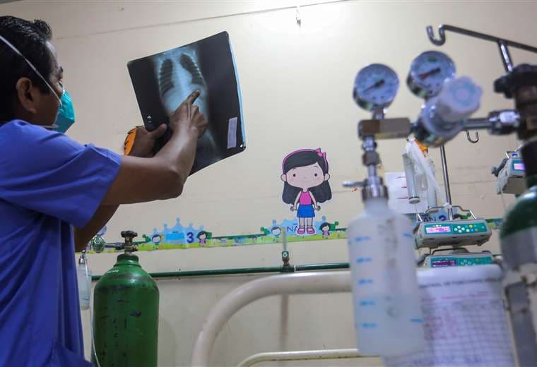 El pediatra Raúl Seminario observa una radiografía de un bebé enfermo de Covid en el hospital de Iquitos. Foto AFP