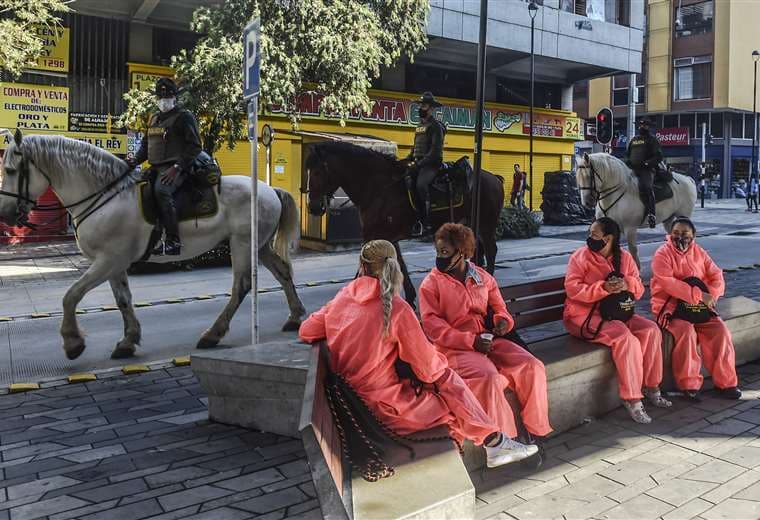 Policías a caballo patrullan en una calle de Medellín el cumplimiento de la cuarentena. Foto AFP