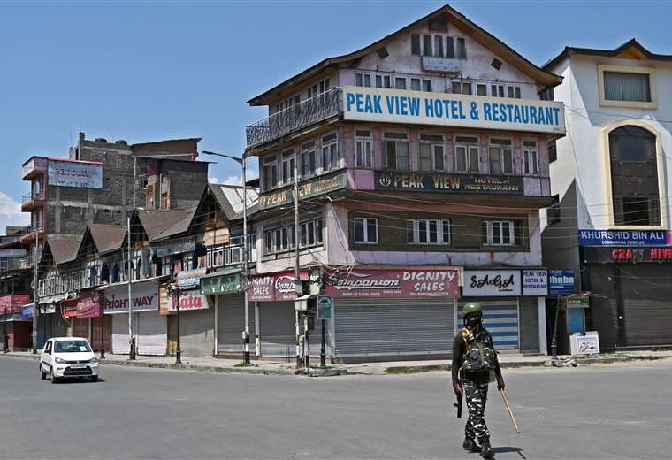 Unsoldado indio patrulla una calle de Srinagar en pleno confinamiento. Foto AFP