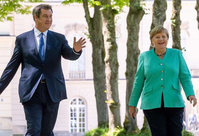 Merkel camina junto a su posible sucesor. Foto AFP