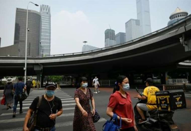 Peatones cruzan una calle de Pekín. Foto AFP