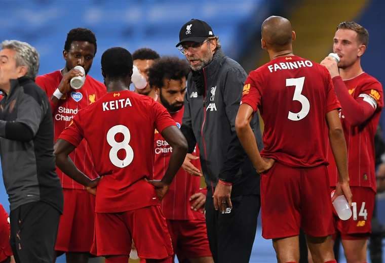 Jürgen Klopp conversa con sus jugadores en el momento de la hidratación. Liverpool no pudo este jueves ante Manchester City. Foto: AFP