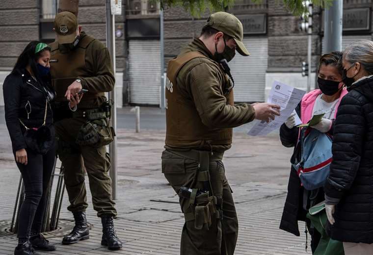 Carabineros piden permisos de circulación a personas en Santiago. Foto AFP