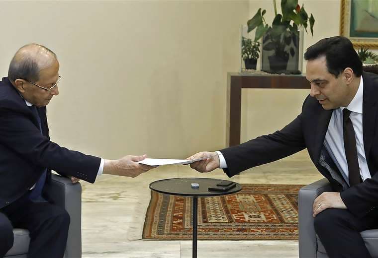 El primer ministro Hassan Diab (derecha) presenta su renuncia al presidente Michel Aoun. Foto AFP
